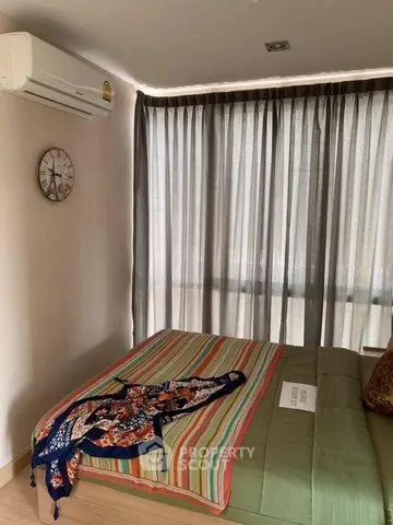 Cozy bedroom with large window and air conditioning in modern apartment.