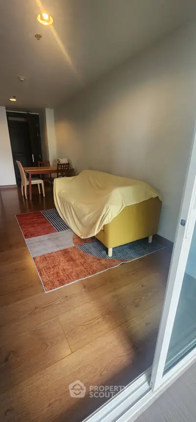Spacious living room with modern furniture and wooden flooring in a stylish apartment.