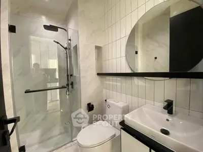Modern bathroom with glass shower and sleek fixtures in a contemporary apartment.