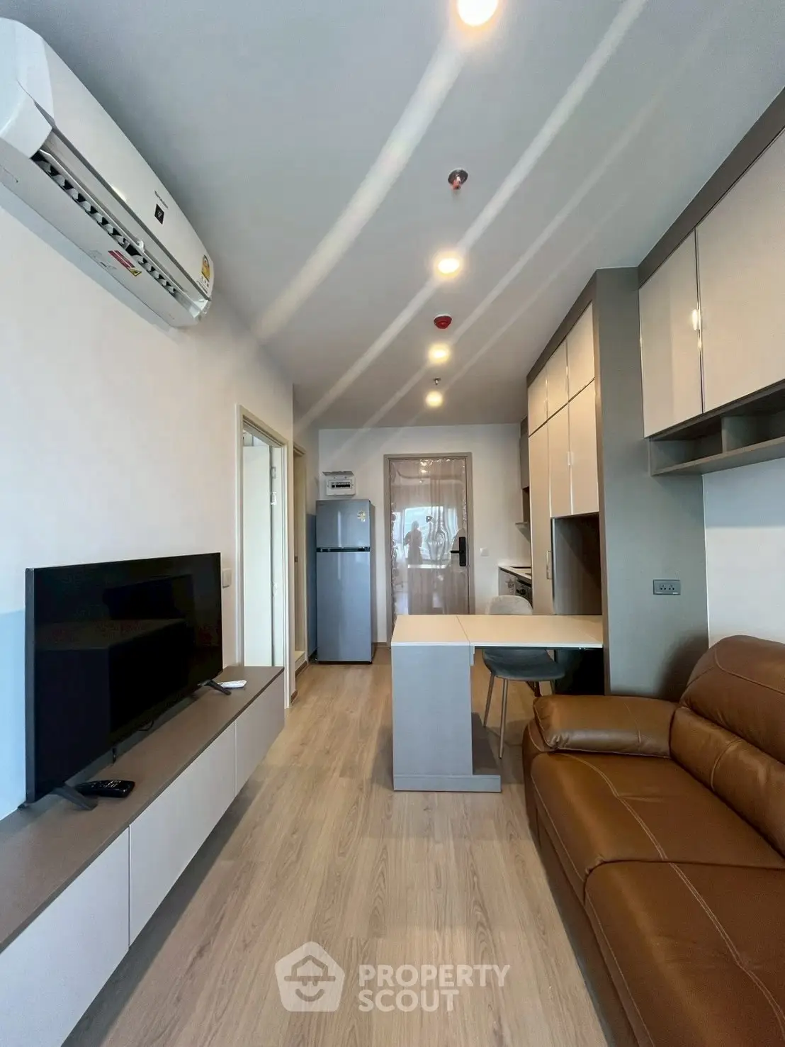 Modern apartment living room with sleek furniture and open kitchen layout