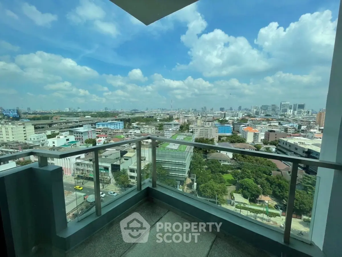 Stunning cityscape view from a high-rise balcony with clear blue skies.