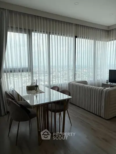 Luxurious corner unit living room with panoramic city views and elegant decor.