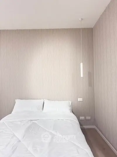 Minimalist bedroom with white bedding and modern lighting