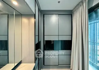 Modern bedroom with sleek built-in wardrobe and large window for natural light.