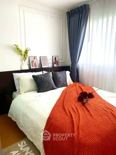 Cozy bedroom with stylish decor and natural light, featuring elegant bedding and modern artwork.