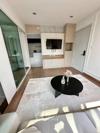 Modern living room with sleek design, featuring a wall-mounted TV, stylish coffee table, and elegant decor.