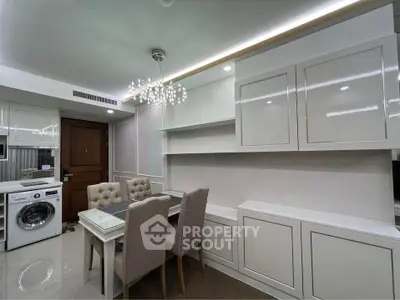 Modern dining area with elegant chandelier and built-in storage in a stylish apartment.