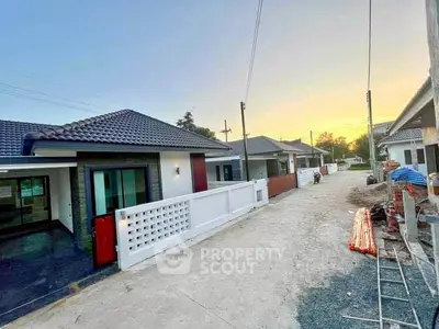 Charming suburban homes with modern design and spacious driveways at sunset.