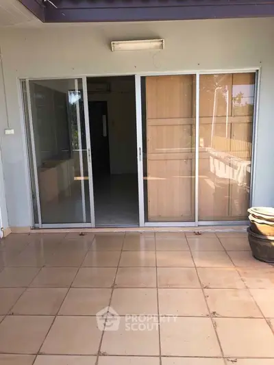 Spacious patio with sliding glass doors leading to interior, perfect for outdoor relaxation.