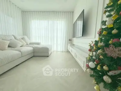 Elegant living room with cozy sofa and festive Christmas tree, perfect for holiday gatherings.