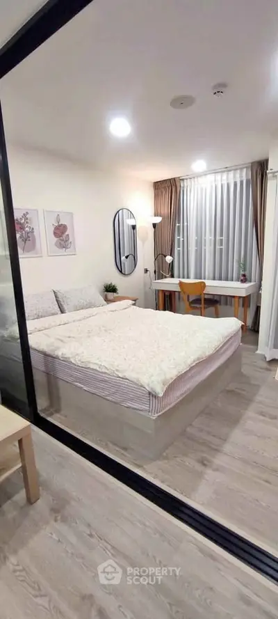 Modern bedroom with stylish decor and workspace, perfect for urban living.