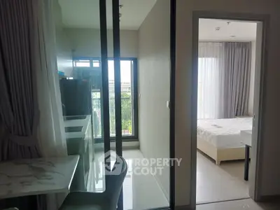 Modern apartment interior with bedroom and balcony view, featuring sleek design and natural light.