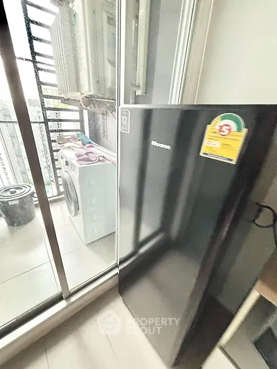 Modern balcony with washing machine and sleek black refrigerator, perfect for urban living convenience.