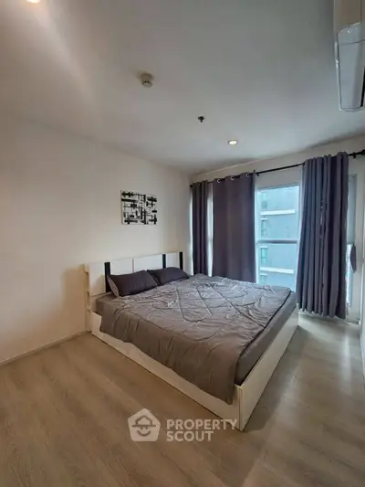 Modern bedroom with large windows and stylish decor in a contemporary apartment.