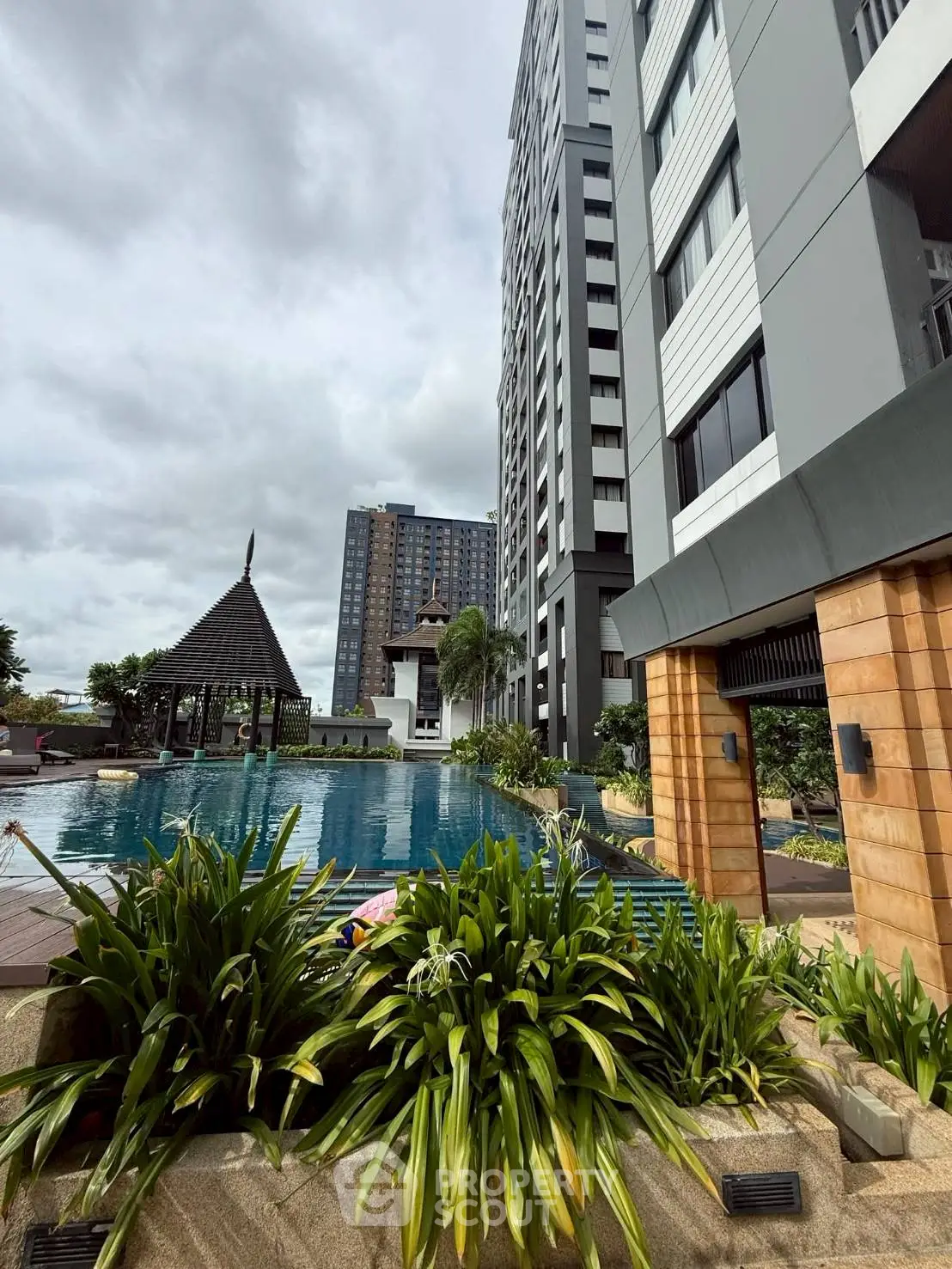 Luxurious apartment complex with stunning pool and lush greenery, perfect for modern urban living.