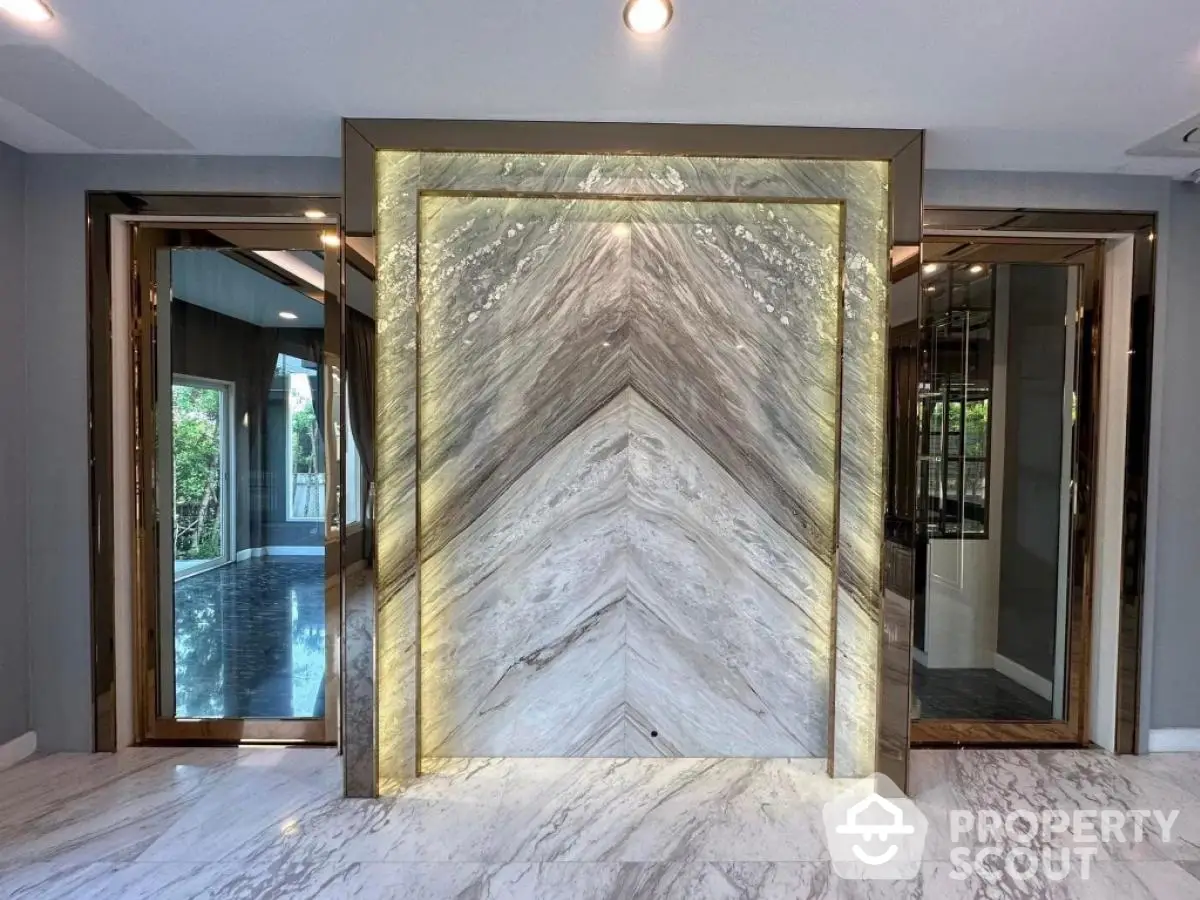 Luxurious modern entrance with marble accents and elegant lighting