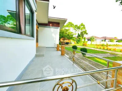 Spacious balcony with elegant railing and scenic garden view in modern home