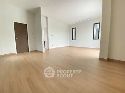 Spacious empty room with wooden flooring and modern design, perfect for customization.