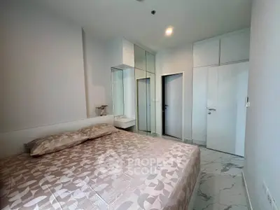 Modern bedroom with stylish decor and mirrored wardrobe in a cozy apartment.