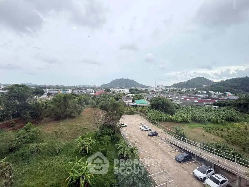 Scenic view from high-rise overlooking lush greenery and distant mountains, ideal for nature lovers.