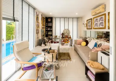 Spacious living room with pool view, elegant decor, and ample natural light