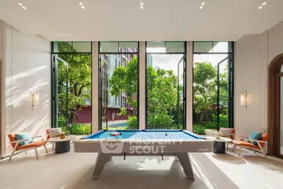Luxurious game room with pool table and garden view, perfect for entertainment and relaxation.