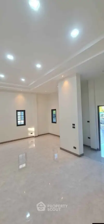 Spacious modern living room with high ceilings and elegant lighting, perfect for family gatherings.
