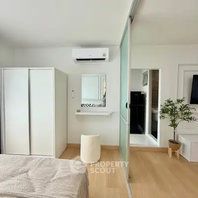 Modern bedroom with sliding glass doors, air conditioning, and minimalist decor.