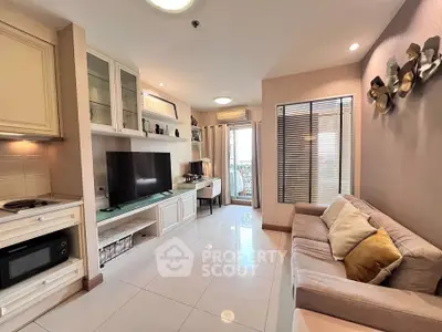 Chic living room with modern decor, large TV, and cozy seating area, perfect for relaxation and entertainment.