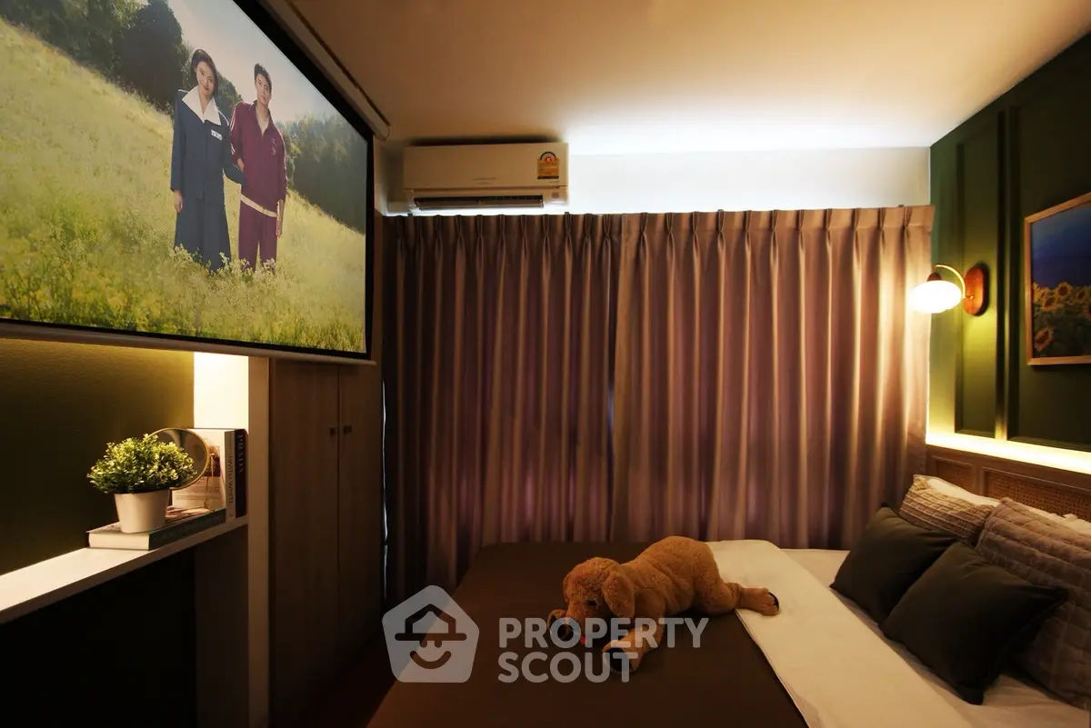 Cozy bedroom with plush decor and ambient lighting, featuring a large screen and elegant curtains.