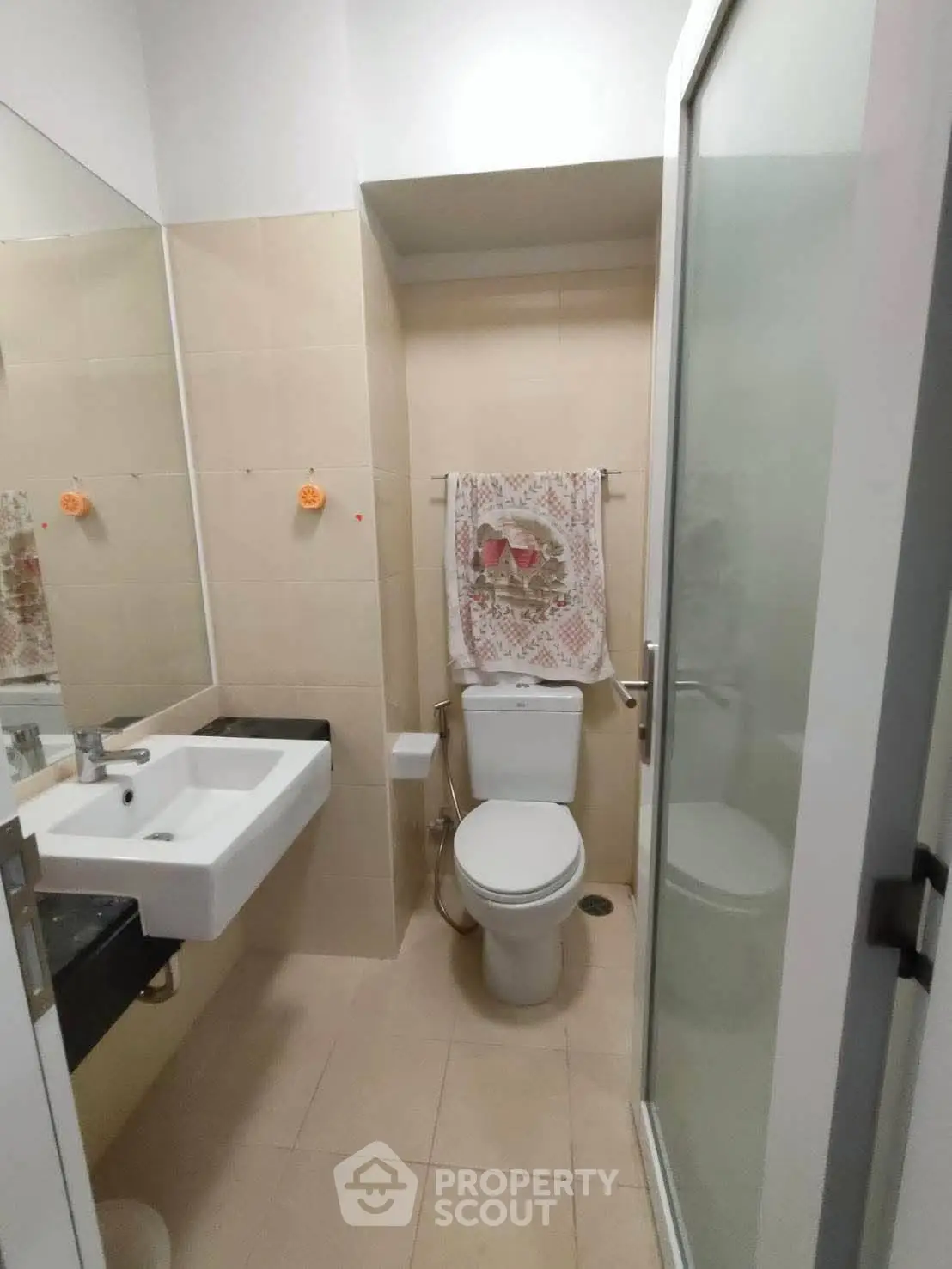 Compact modern bathroom with sleek fixtures and frosted glass door