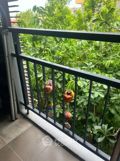 Charming balcony with lush green view and decorative hanging planters.