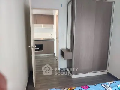 Modern apartment interior with compact kitchen and stylish bedroom wardrobe.