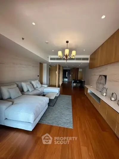 Spacious modern living room with elegant wooden flooring and cozy seating area.