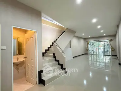Spacious modern living room with staircase and large windows for natural light