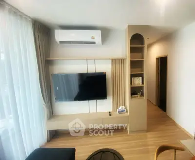 Modern living room with wall-mounted TV and air conditioning in a stylish apartment.