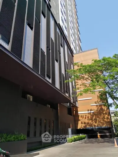Modern high-rise building exterior with sleek design and lush greenery