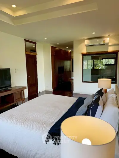 Spacious bedroom with modern decor and large window view