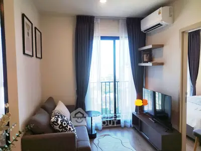 Modern living room with balcony and city view, featuring stylish decor and natural light.