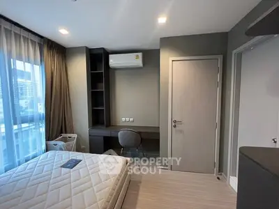 Modern bedroom with study area and city view, featuring sleek design and natural light.