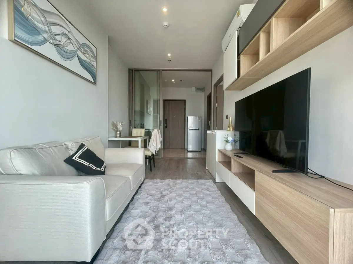 Modern living room with sleek furniture and large TV, perfect for relaxation.