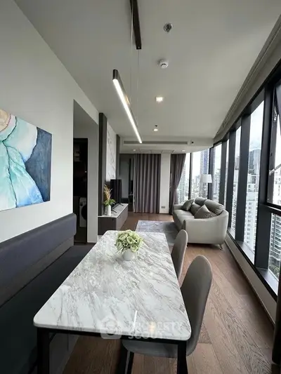 Modern living room with panoramic city views and elegant marble dining table.