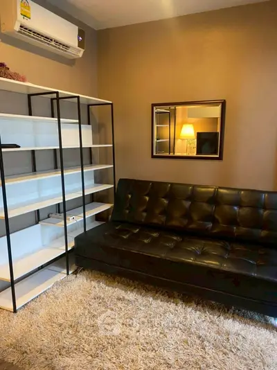 Cozy living room with modern black leather sofa and sleek shelving unit