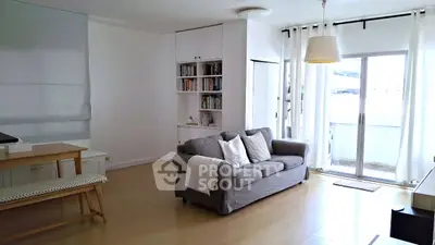 Spacious living room with cozy sofa and balcony access in modern apartment.