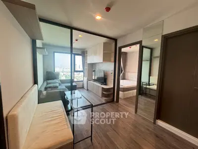 Modern apartment interior with glass partition, cozy living area, and city view.