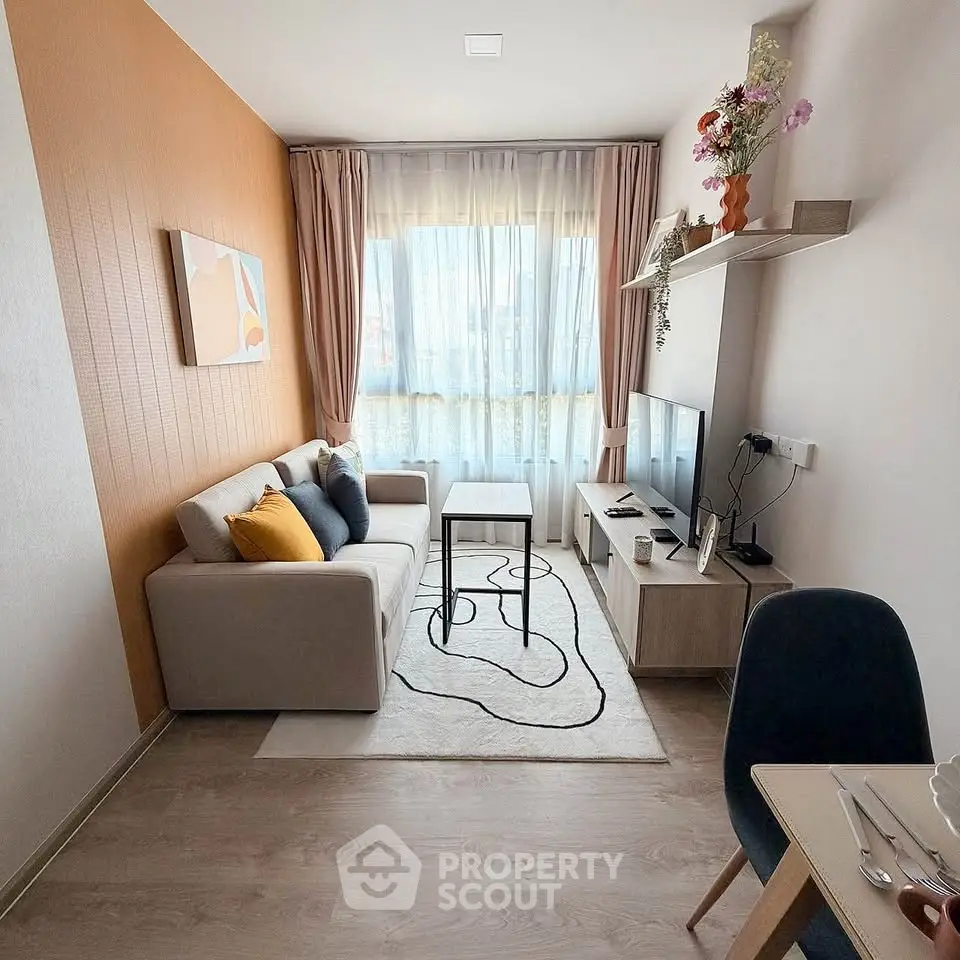 Modern living room with stylish decor and natural light, featuring a cozy sofa and entertainment setup.