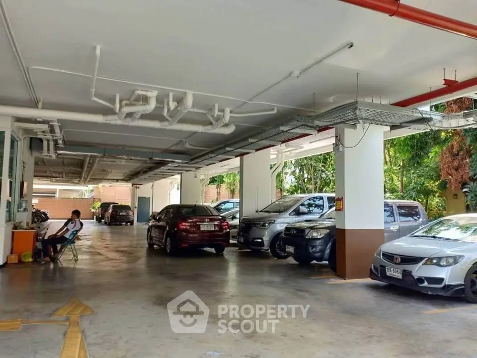Spacious covered parking area with multiple cars in a residential building.
