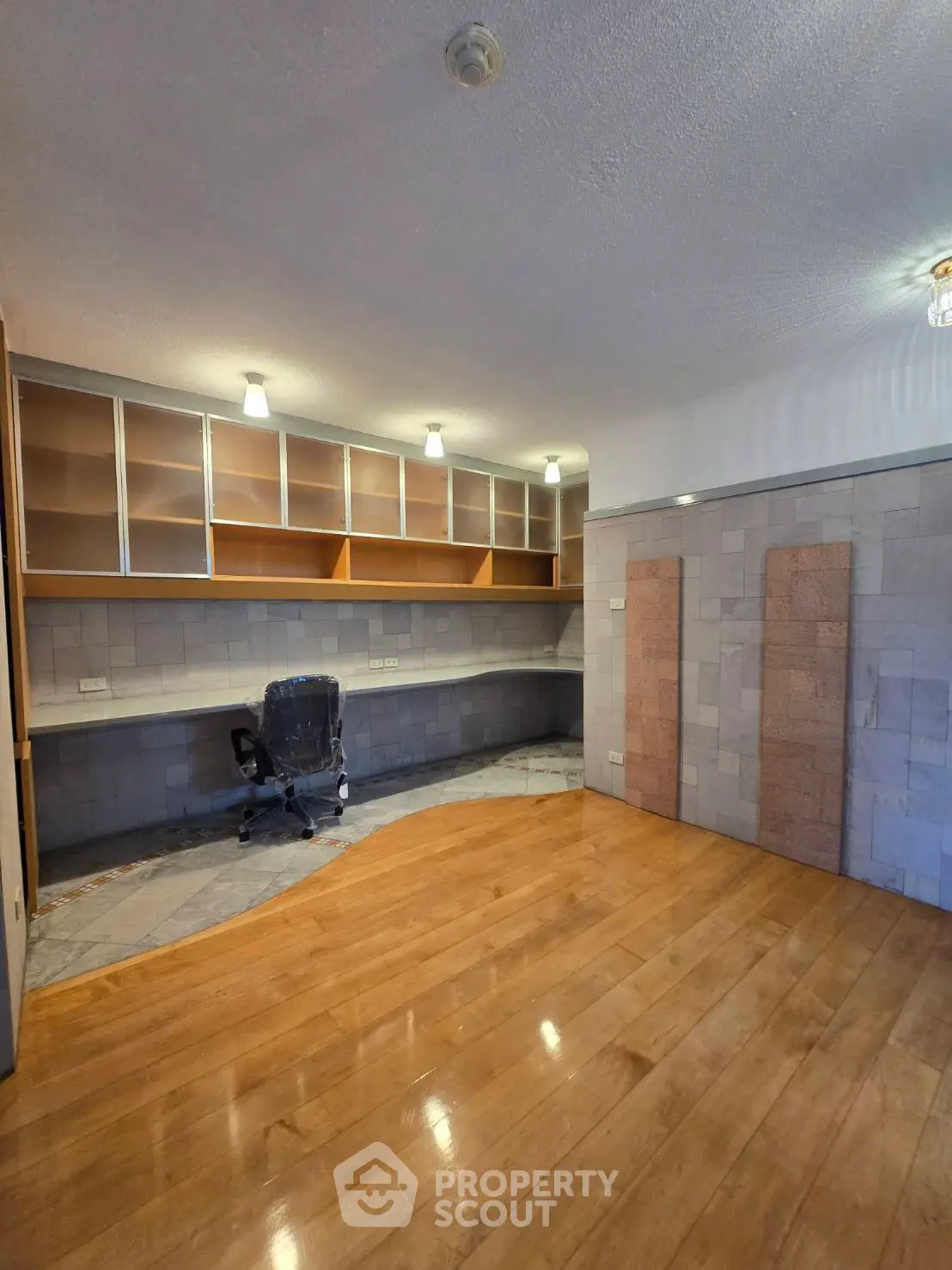 Spacious study room with built-in shelves and wooden flooring