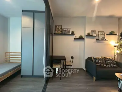 Modern living room with cozy sofa and dining area, featuring stylish decor and wooden flooring.