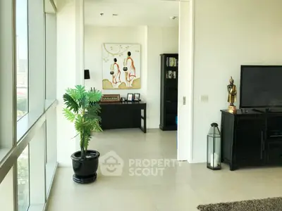 Spacious living room with modern decor and large windows offering city views.